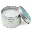 Vela perfumada de vainilla en recipiente metálico plateado con acabado texturizado y tapa decorativa parcialmente abierta
